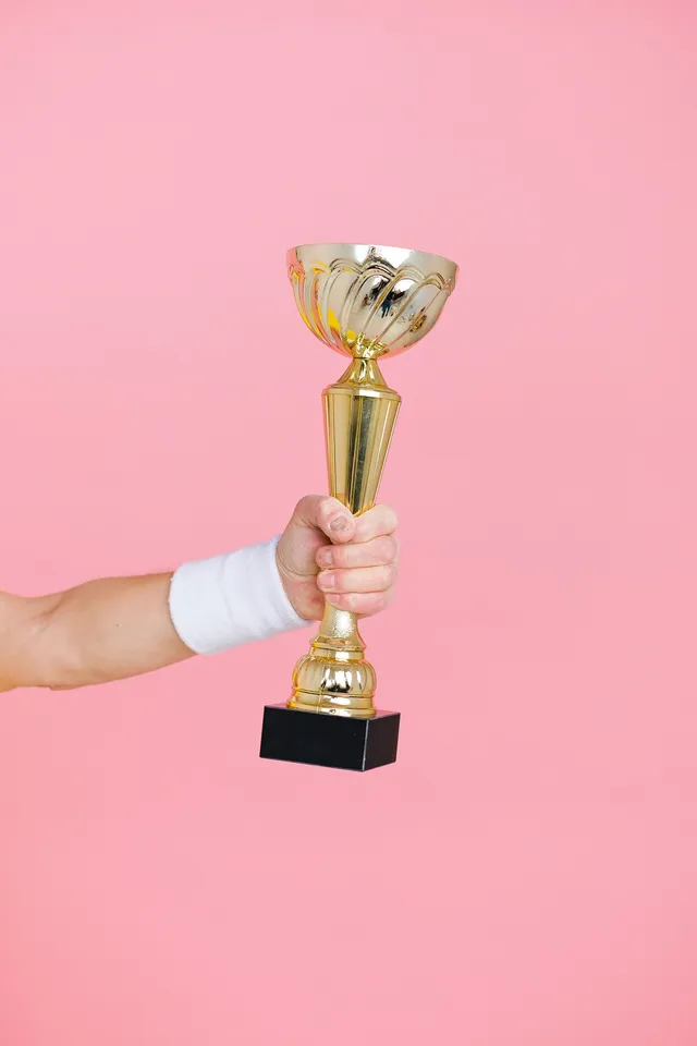 Pessoa segurando troféu dourado, simbolizando ranking de ferramentas