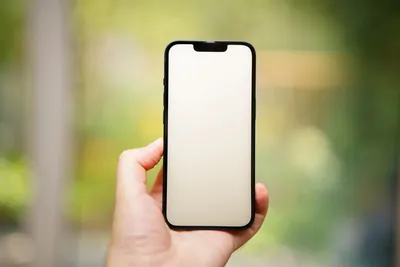 Mão segurando smartphone com tela em branco ao ar livre