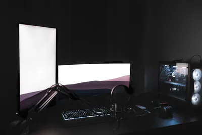 Configuração de computador com múltiplos monitores em ambiente escuro